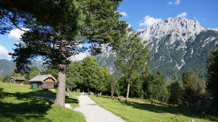 Fototapeta na wymiar Steingarten auf dem Wanderweg vom Lautersee nach Mittenwald mit Karwendelgebirge und Hütten