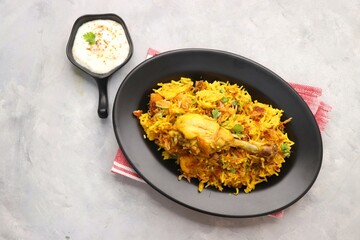Chicken Biryani/murg Pulao.  Garnished with fried onion & chopped coriander. Biryani raita is a famous Spicy non vegetarian dish of India. Chicken cooked along with Basmati rice & spices. copy space.