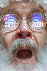 Close up shot of Santa Claus in stylish glasses with a reflection of 2021 Happy New Year and salute. Looks delighted, shocked, astonished, emotional. Facial expression, emotions, Christmas, winter