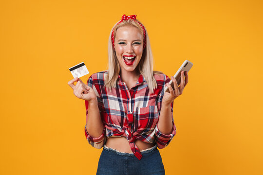 Image of excited pinup girl posing with credit card and mobile phone