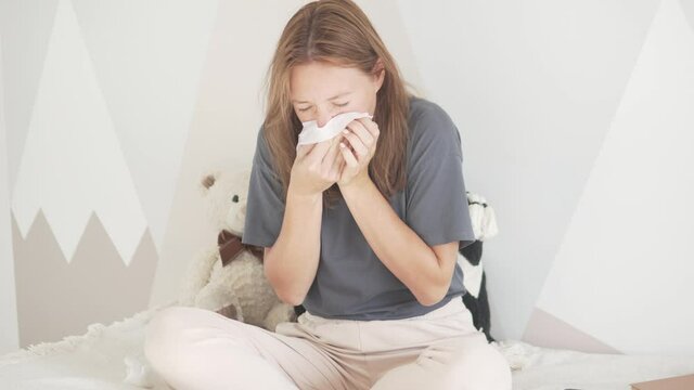 A beautiful woman blowing her nose. Young mother got sick