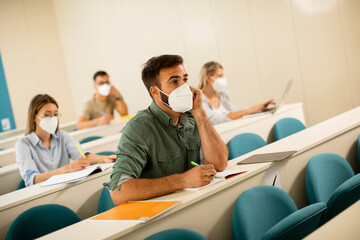 Male student wearing face protective medical mask for virus protection at lecture hall