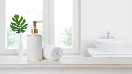 Soap dispenser on table against blurred bathroom window background - obrazy, fototapety, plakaty