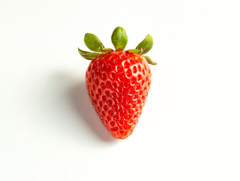 A close-up picture of a bright one red strawberry or berry as a fruit or food. An isolated white background is a naturally fresh fruit.