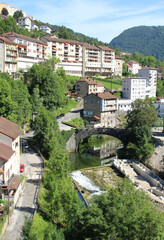 Obraz premium View of the picturesque town of Sainte Claude in the Haut Jura region of France. Appartment buildings overlooking the river.