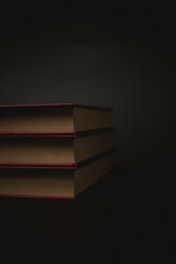 three old red books with yellow pages on black background. High quality photo