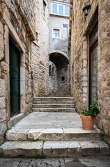Fototapeta na wymiar Medieval narrow street with a turn in Sibenik, Croatia