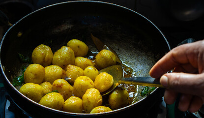 The cooking of Dum aloo Indian dish in the making
