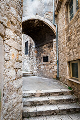 Fototapeta na wymiar Medieval narrow street with a turn in Sibenik, Croatia