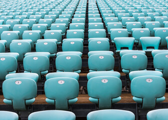 Obraz premium The rows of numbered turquoise chairs stretching into the distance