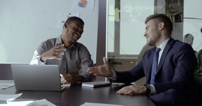 Two successful businessmen wear suits, african salesman and caucasian banker manager handshake, happy mixed race client customer and young investor at business meeting discus deal, conclude agreement
