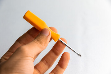 Little toy screwdriver in boy's hand on plain white background