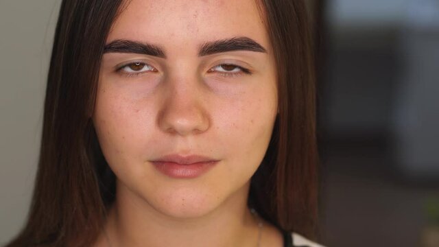 Closeup view 4k video portrait of young teenage pretty girl looking at camera. Result of modern trendy professional eyebrow tinting procedure.