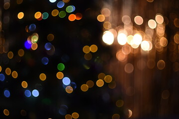 Background with bright multicolored glowing bokeh lights on gold and dark green background 
