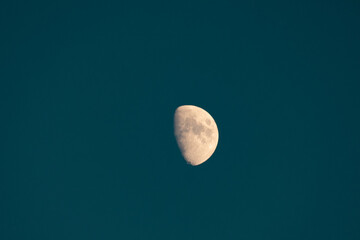 luna senza stelle in cielo blu piombo con crateri visibili