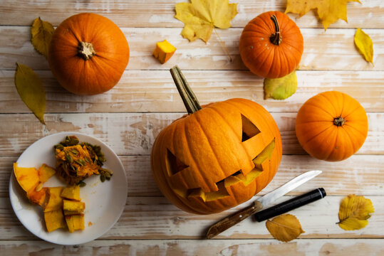 Halloween Carving. Close Up Of Pumpkins Or Jack-o-lantern And Knife At Home. Decoration And Holidays Concept