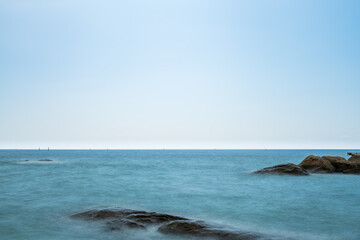 sea and beautiful blue sky with reef or rock in thailand at afternoon with copy space (long exposure)