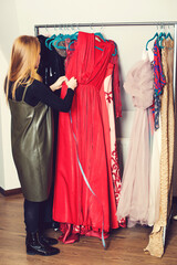 Woman measuring dress at workshop. Successful fashion business. Dressmaking studio or boutique.