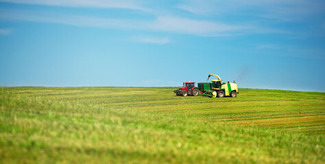 Obraz premium Agriculture. Mowing meadows. Technology. Farmer mowing his field on the tractor. 