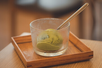 Green tea matcha ice cream scoop in glass bowl