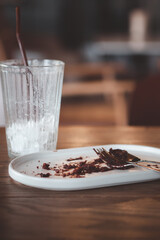 Dirty plate with cake crumbs leftovers and dirty a glass after enjoy eating