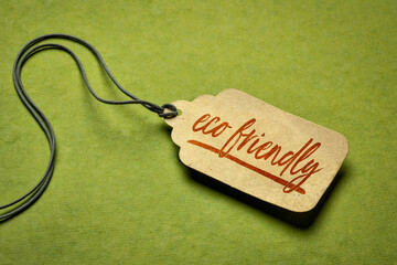 eco friendly sign - a paper tag with a twine on green background, environmental concept