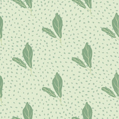 Pale seamless doodle pattern with leaves simple silhouettes. Green floral nature print on grey dotted background.