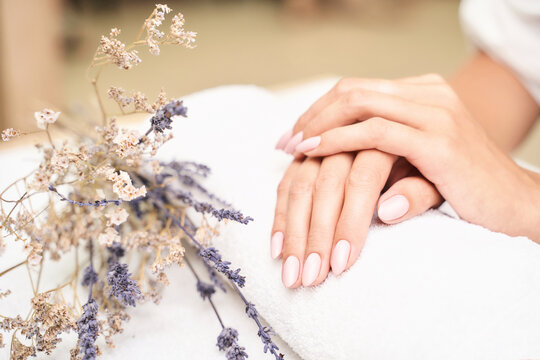 Classic pink wedding nail manicure on white backdrop. Spa treatment concept. Towel background. Natural hygiene. Health care. Beauty spa salon. Salon procedure Woman body care. Lavender flower