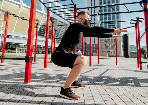 masked man doing exercises outdoors
