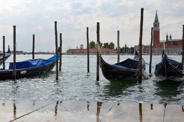 Fototapeta na wymiar Gondolas in Venice with Saint Giorgio island in the morning, seen from San Marco square, Italy