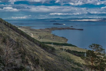 Fototapeta na wymiar top view of the bay of lake Baikal with islands, peninsulas, clouds, blue sky, mountains and hill, before the rain
