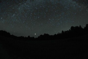 Blue dark night sky with many stars. Night sky over rural landscape. high ISO landscape with fisheye lens