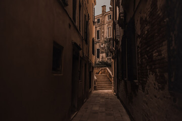 Fototapeta na wymiar Architecture and landmarks of Venice, Italy. Ancient brick and beige buildings, narrow streets between the houses, tiled roofs.