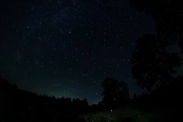Blue dark night sky with many stars. Night sky over rural landscape. high ISO landscape with...