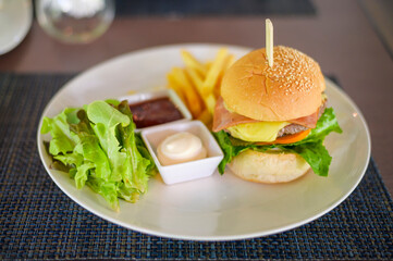 Large of tasty burger with beef, tomato, cheese and lettuce served in a plate