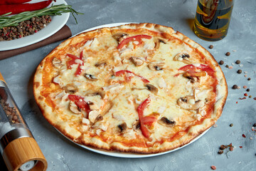 Italian pizza with bacon, mushrooms, tomatoes, melted cheese on a gray background. Top view, food flat lay