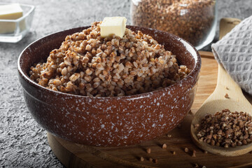Boiled buckwheat with butter. Ready-made buckwheat in a deep dish on the table.