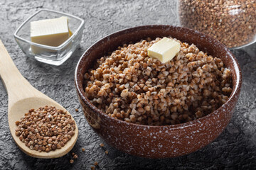 Boiled buckwheat with butter. Ready-made buckwheat in a deep dish on the table.