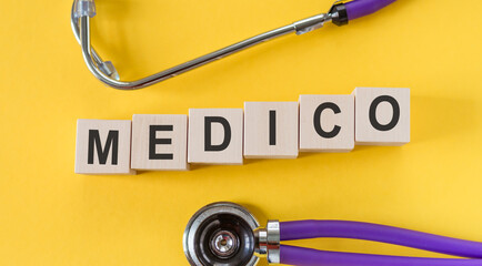 MEDICO text made in building wood blocks on yellow desk