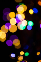 Christmas multicolored lights in defocus on a dark background
