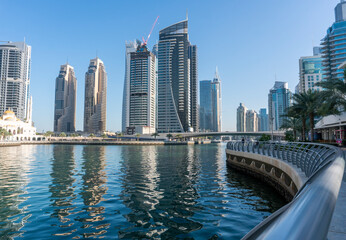Fototapeta na wymiar Jacht and Skyscrapers Above the Water of Persian Gulf in Dubai Marina District in UAE