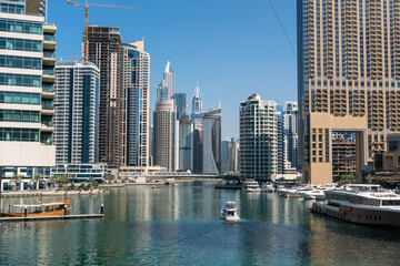 Fototapeta na wymiar Jacht and Skyscrapers Above the Water of Persian Gulf in Dubai Marina District in UAE