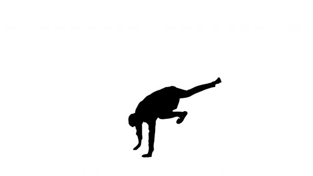 Silhouette Young man dressed in white shirt and black pants jumping in the frame and starting to dance break looking at camera.