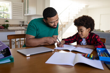 Naklejka premium Father helping son with homework at home