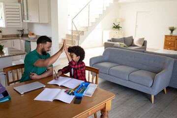 Father and son high fiving each other at home