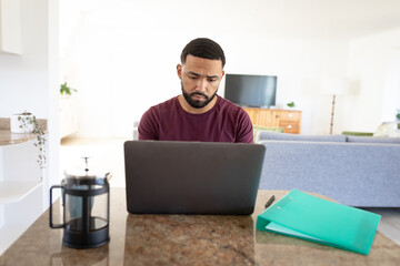 Stressed man using laptop at home