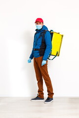 contactless food delivery to customers home. Delivery service worker with thermal backpack quick delivering food at doorstep in quarantine from restaurant, supermarket or cafe . Online ordering food