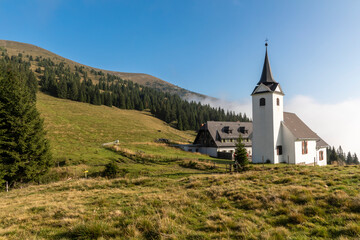 Fototapeta na wymiar mountain range Gleinalm or Gleinalpe with summit Speikkogel and mountain hut named Gleinalmschutzhaus with chapel in the Austrian federal state of Styria