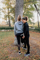 A couple of women stretching outdoors in the park
