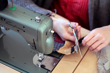 Sewing with machine. Detail of tailor hand working with fabric